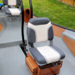 Padded oarsman seat on adjustable tracking rails in front of adjustable rear kneelocks.